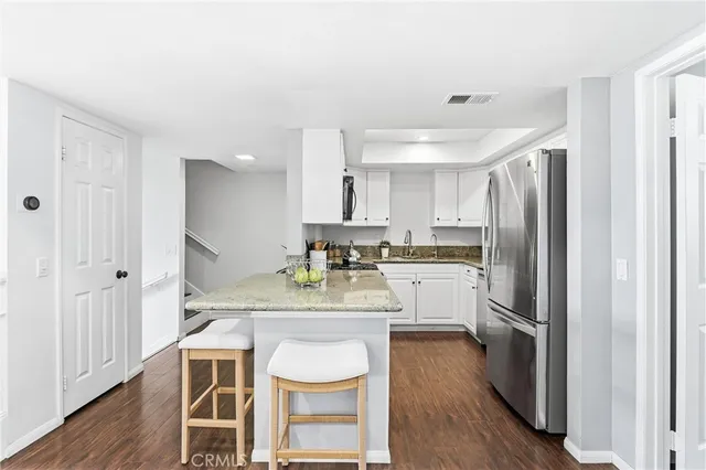 a kitchen with a refrigerator a sink and white cabinets