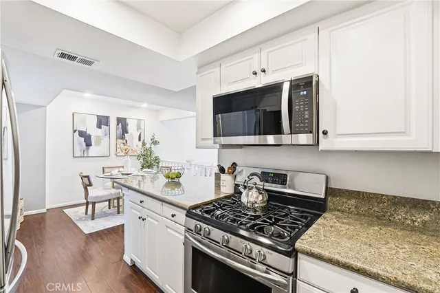 a kitchen with stainless steel appliances granite countertop a stove and a microwave