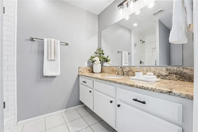 a bathroom with a granite countertop sink and a mirror