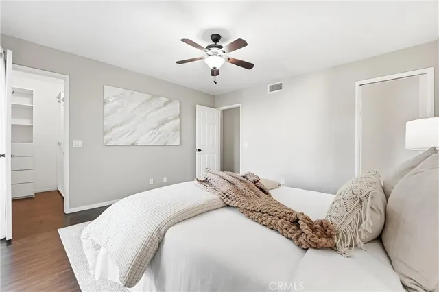 a bedroom with a large bed and a chandelier
