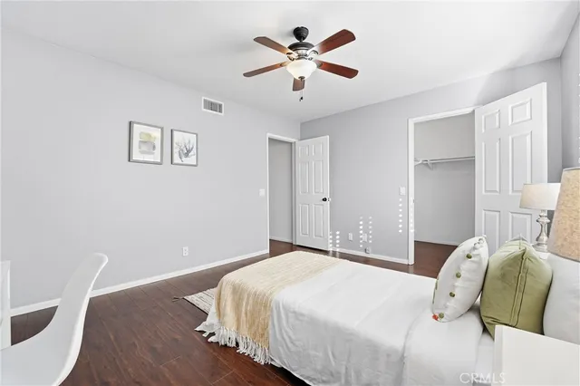 a bedroom with a bed and a ceiling fan