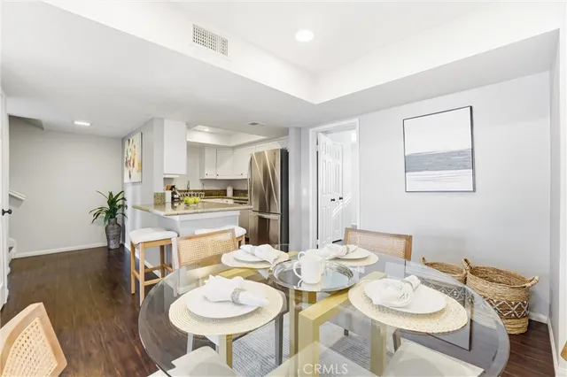 a dining room with furniture a kitchen view and wooden floor