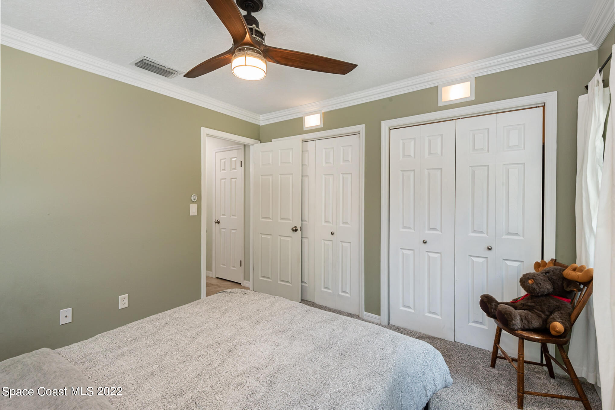 395 Rio Lane Indialantic, FL 32903 - Photo 31 of 40 a bedroom with a bed and a chair