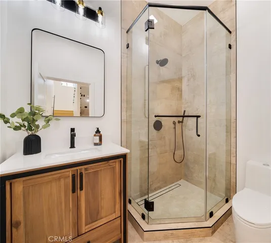 a bathroom with a granite countertop sink a toilet and shower