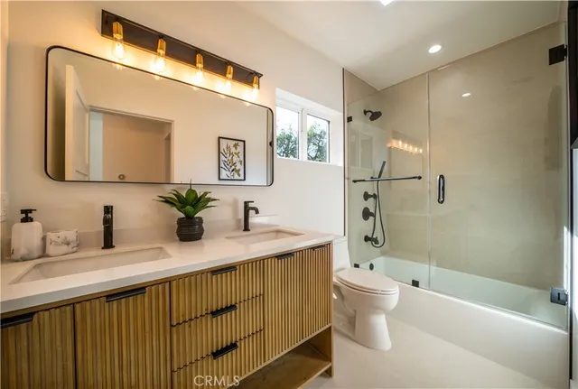 a bathroom with a granite countertop sink mirror toilet and bathtub
