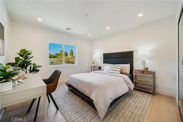 a bedroom with a bed and a potted plant
