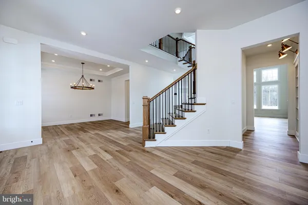 a view of an empty room with a window and a kitchen