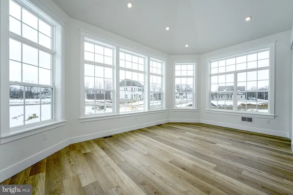 a view of a hallway with wooden floor and closet