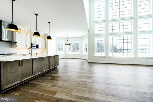 a view of a kitchen with kitchen island a sink wooden floor and window