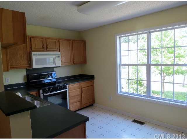 1015 Piney Church Road Concord, NC 28025 - Photo 5 of 13 a kitchen with granite countertop a stove a sink and a microwave