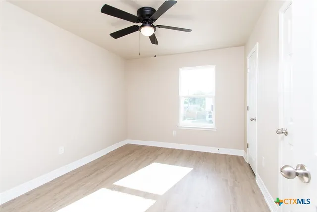 a view of a big room with wooden floor and windows in a room