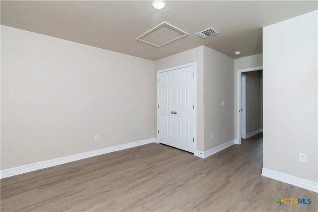 a view of an empty room with wooden floor