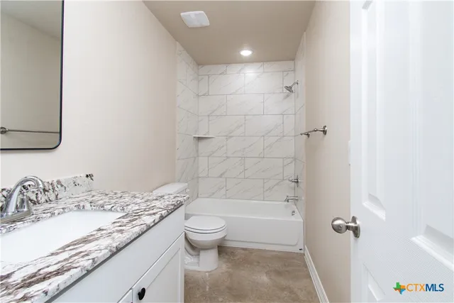 a bathroom with a granite countertop sink a toilet and shower