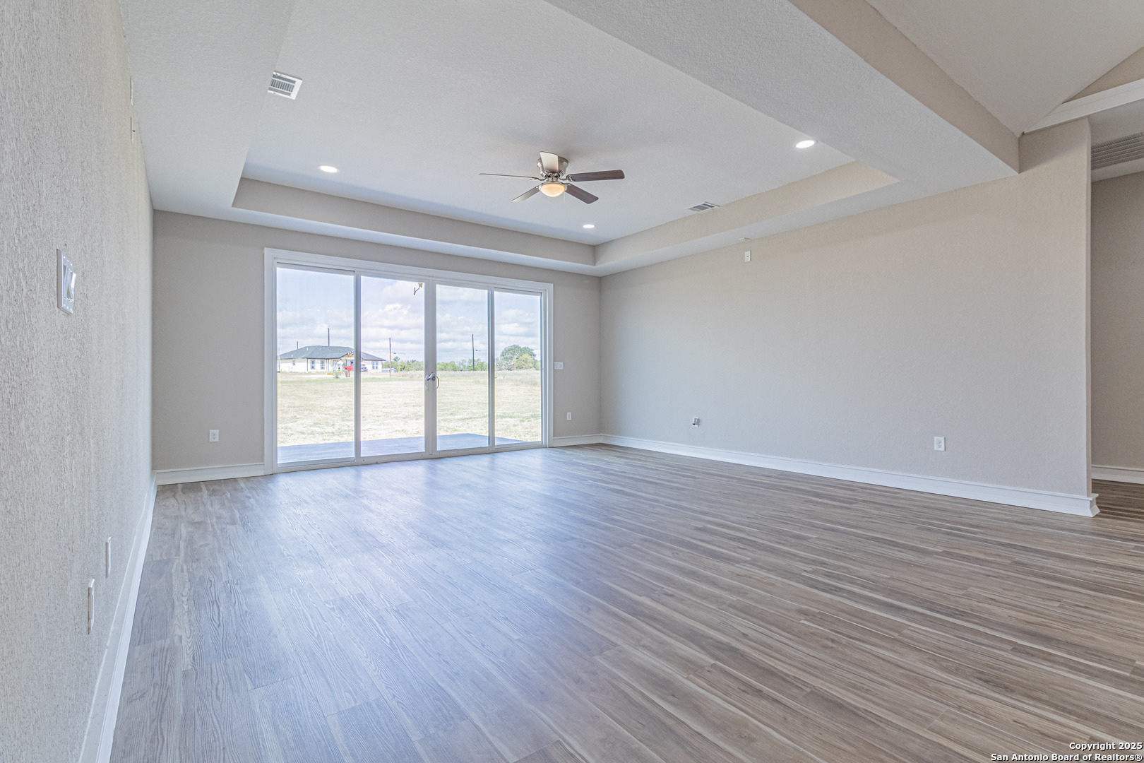 16923 Rancho Escondido Atascosa, TX 78002 - Photo 12 of 35 an empty room with wooden floor and windows