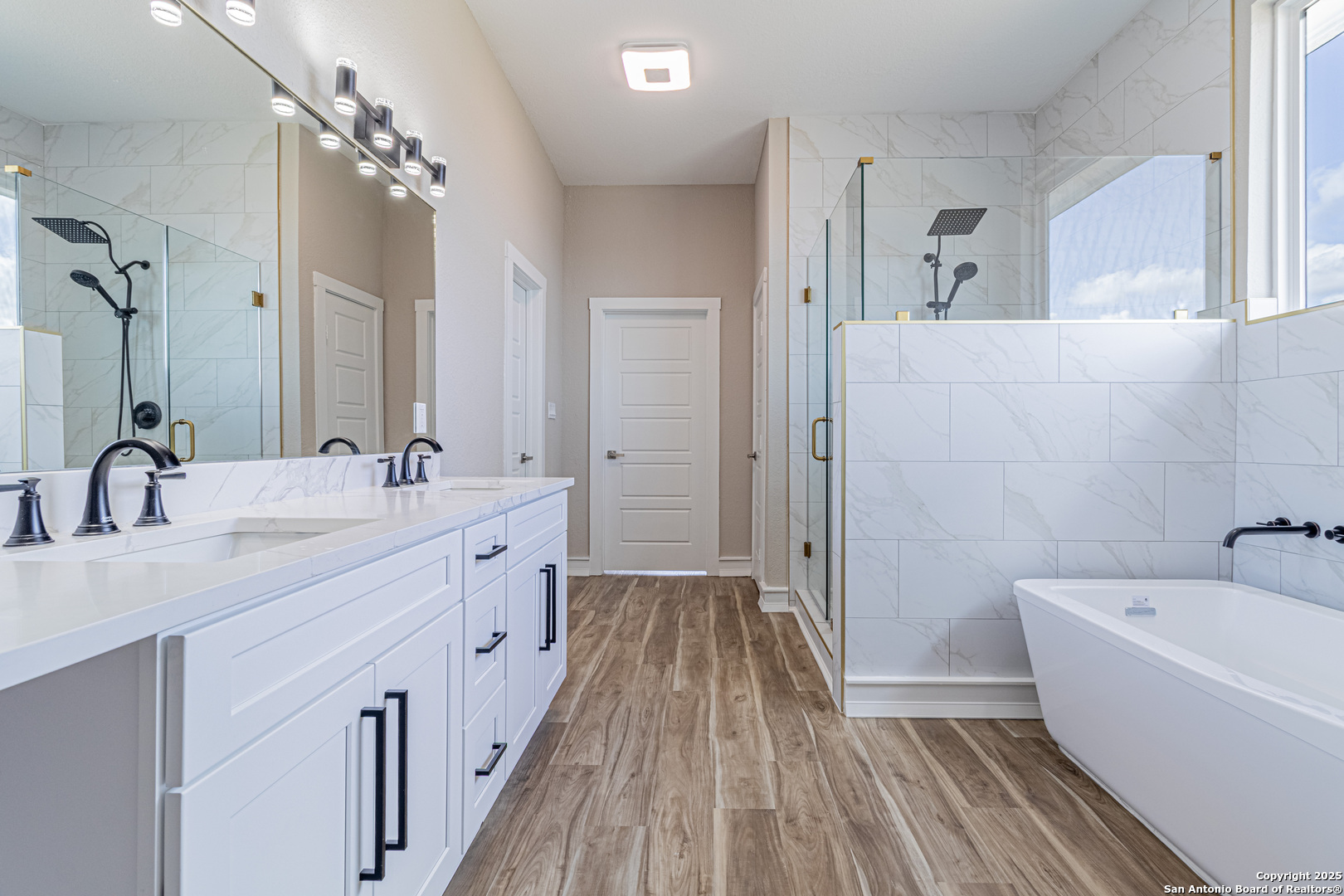 16923 Rancho Escondido Atascosa, TX 78002 - Photo 20 of 35 a bathroom with a double vanity sink a mirror a bathtub and shower