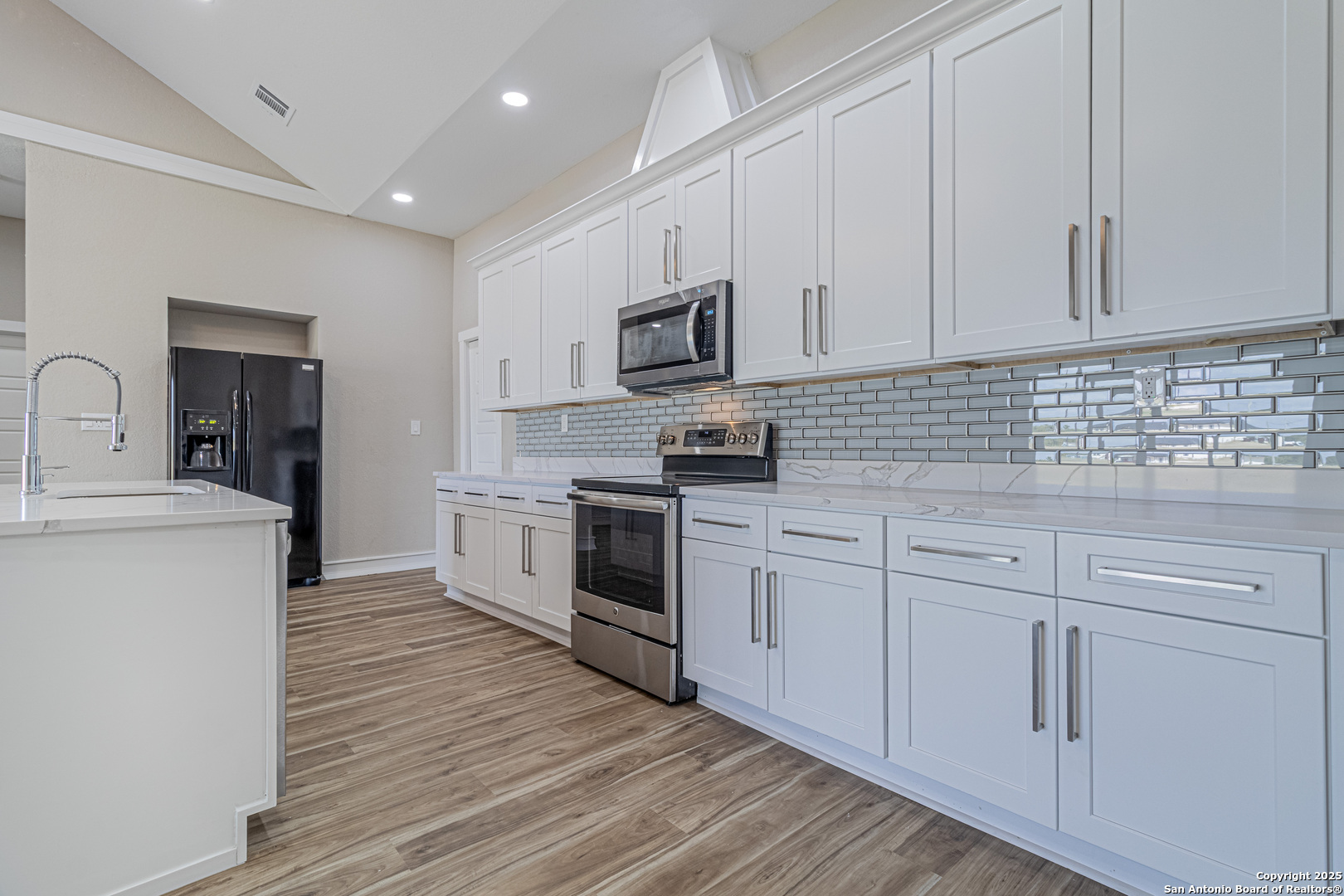 16923 Rancho Escondido Atascosa, TX 78002 - Photo 6 of 35 a kitchen with white cabinets stainless steel appliances and sink