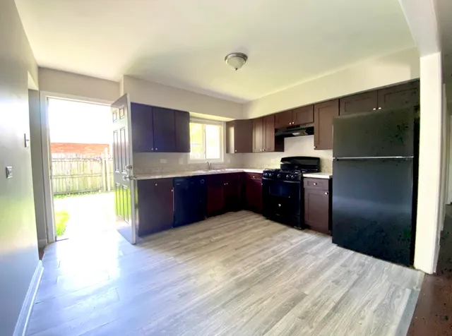 a kitchen with granite countertop a refrigerator and a sink
