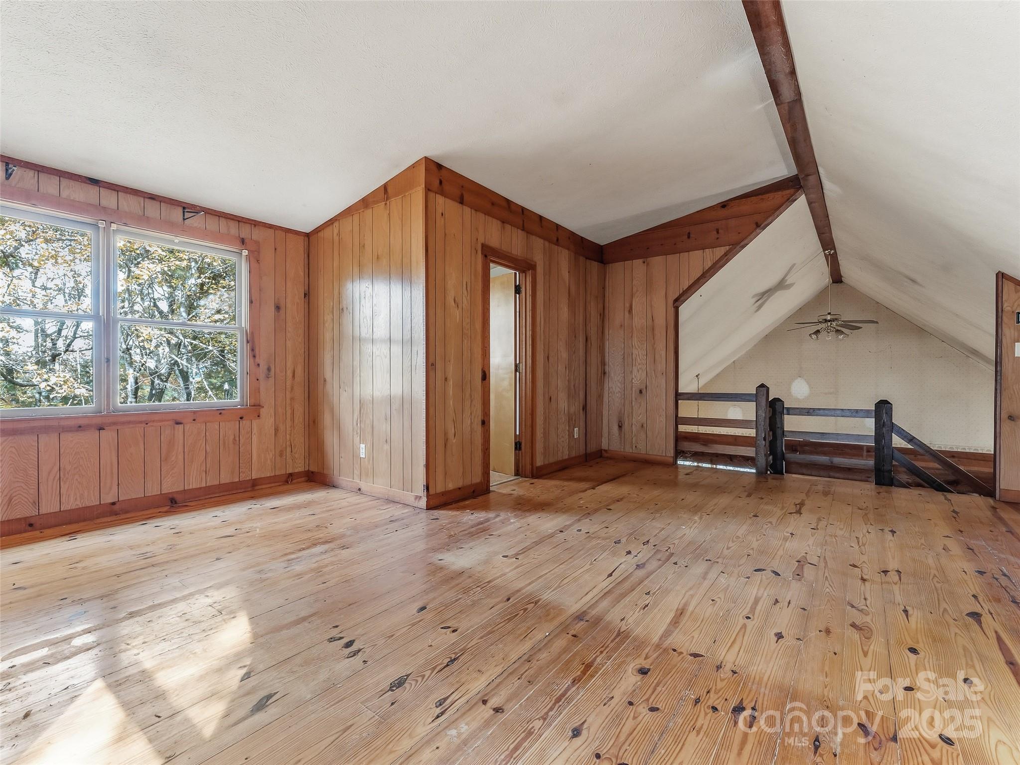 6130 Howard Gap Road Saluda, NC 28773 - Photo 13 of 27 an empty room with wooden floor and windows