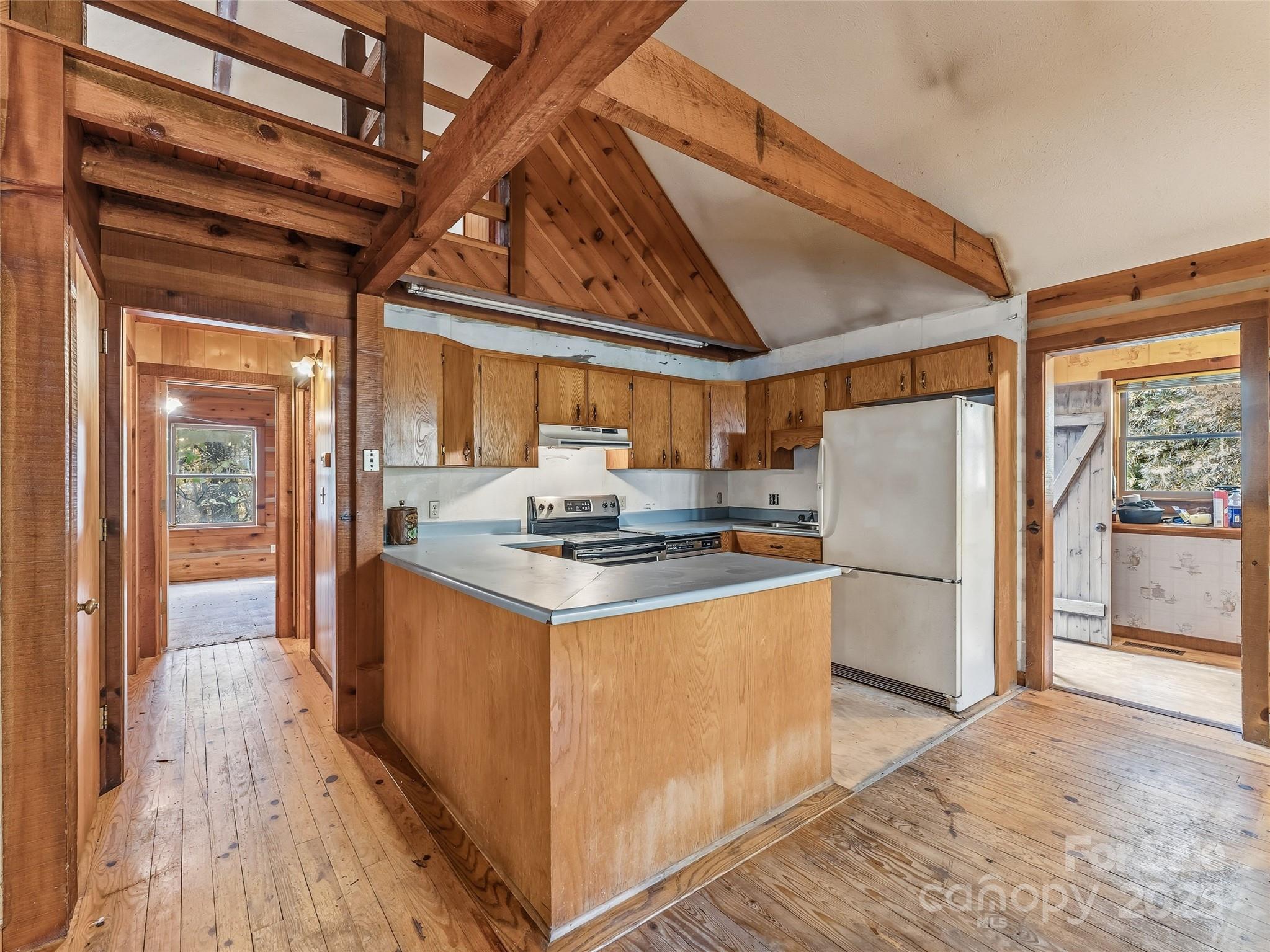6130 Howard Gap Road Saluda, NC 28773 - Photo 10 of 27 a kitchen with refrigerator and white cabinets