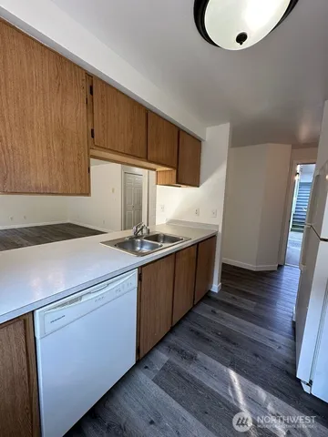 a kitchen with kitchen island granite countertop wooden cabinets and white appliances