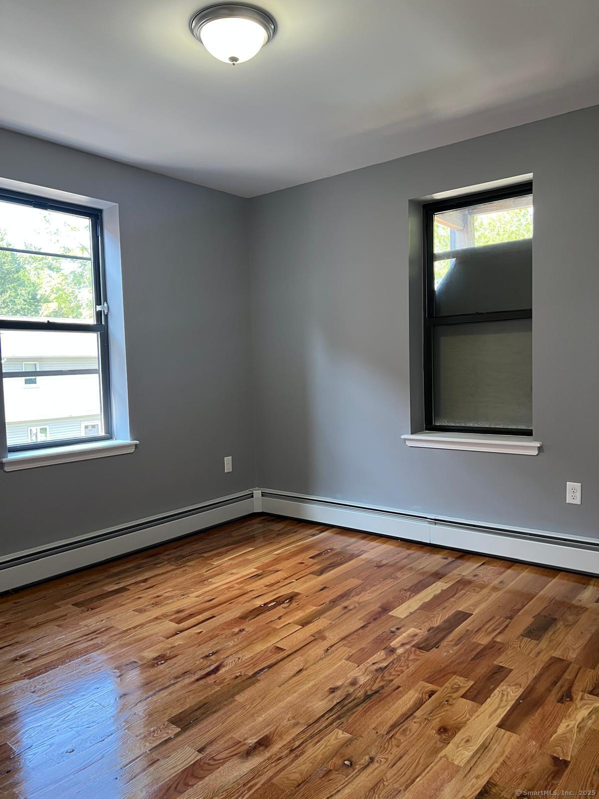79 Barbour Street, Unit N2 Hartford, CT 06120 - Photo 5 of 7 a view of an empty room with wooden floor and a window