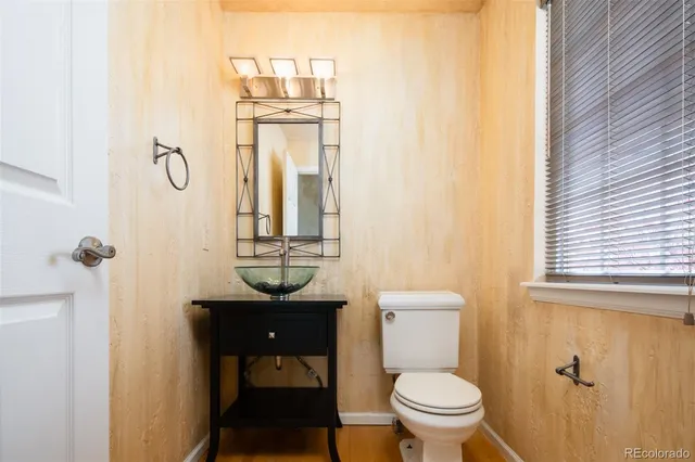 a bathroom with a toilet a sink and mirror