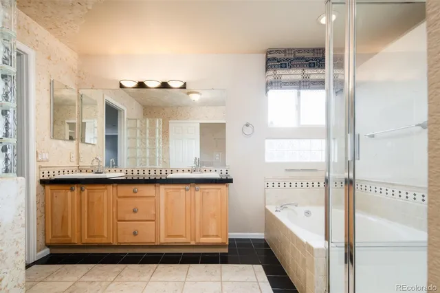 a bathroom with a tub a sink and mirror