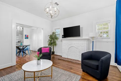 a living room with furniture a flat screen tv and a window