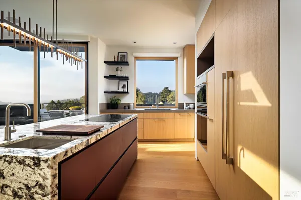 a kitchen with stainless steel appliances granite countertop a sink and a refrigerator