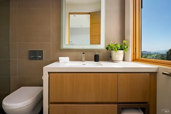 a bathroom with a granite countertop sink toilet and mirror
