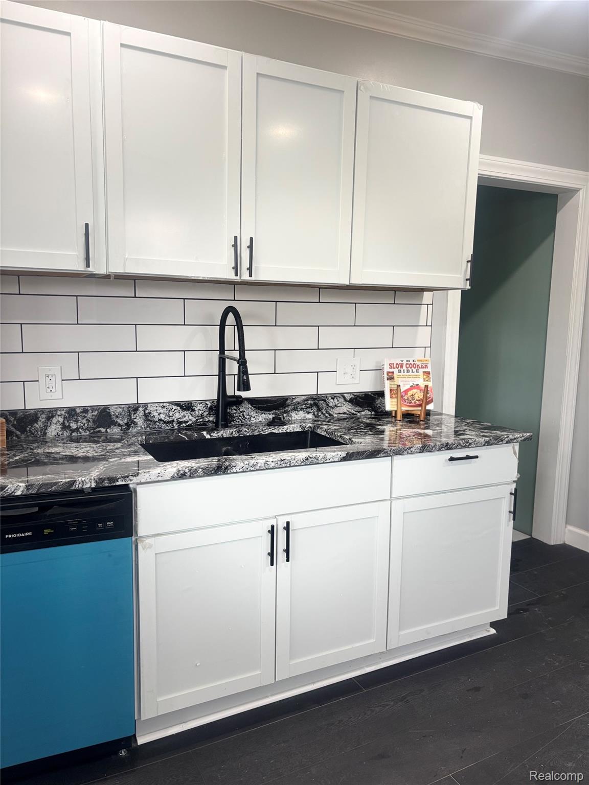 5012 Fischer Street Detroit, MI 48213 - Photo 4 of 22 Kitchen featuring dark stone counters, dishwashing machine, white cabinetry, backsplash, and ornamental molding