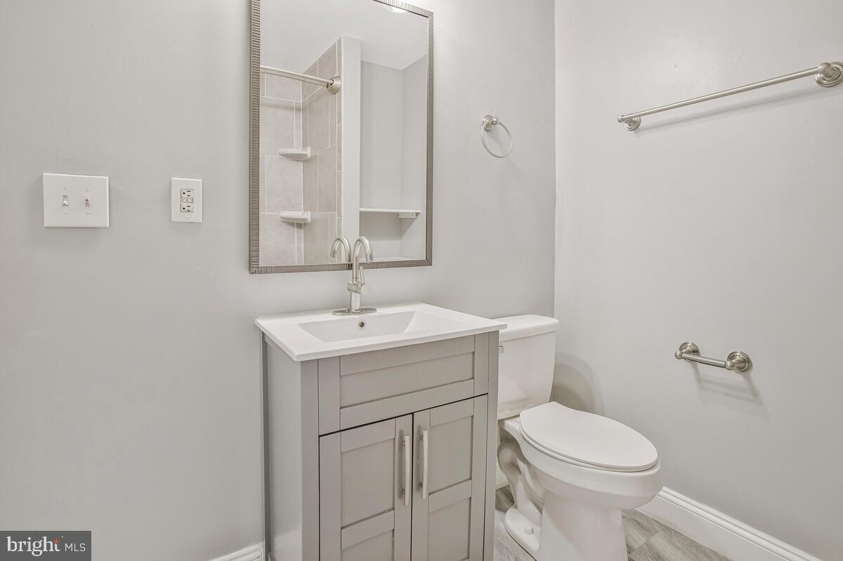 823 Newington Avenue Baltimore, MD 21217 - Photo 11 of 30 a white toilet sitting next to a bathroom sink