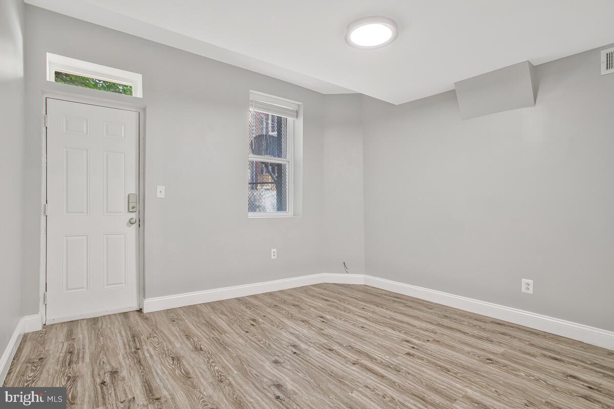 823 Newington Avenue Baltimore, MD 21217 - Photo 13 of 30 an empty room with wooden floor and windows