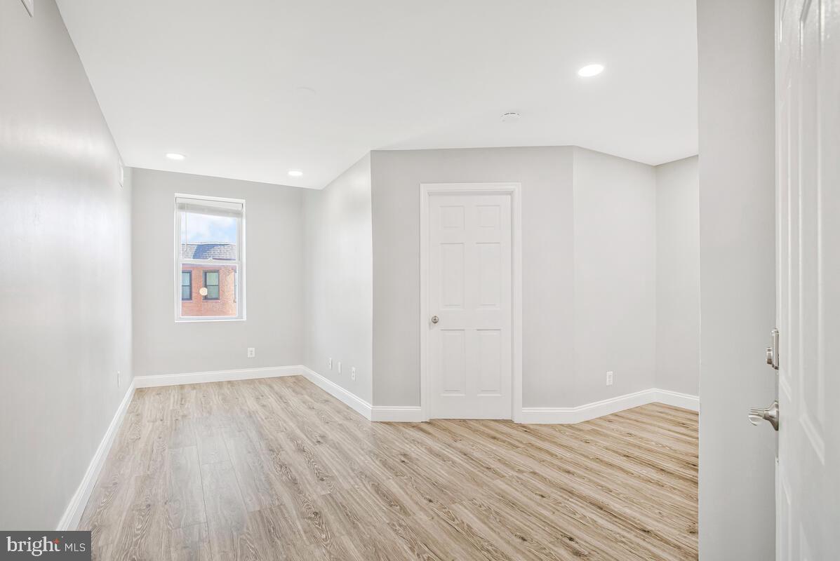 823 Newington Avenue Baltimore, MD 21217 - Photo 18 of 30 wooden floor in an empty room with a window