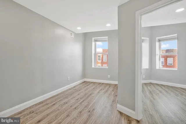 a view of an empty room with wooden floor