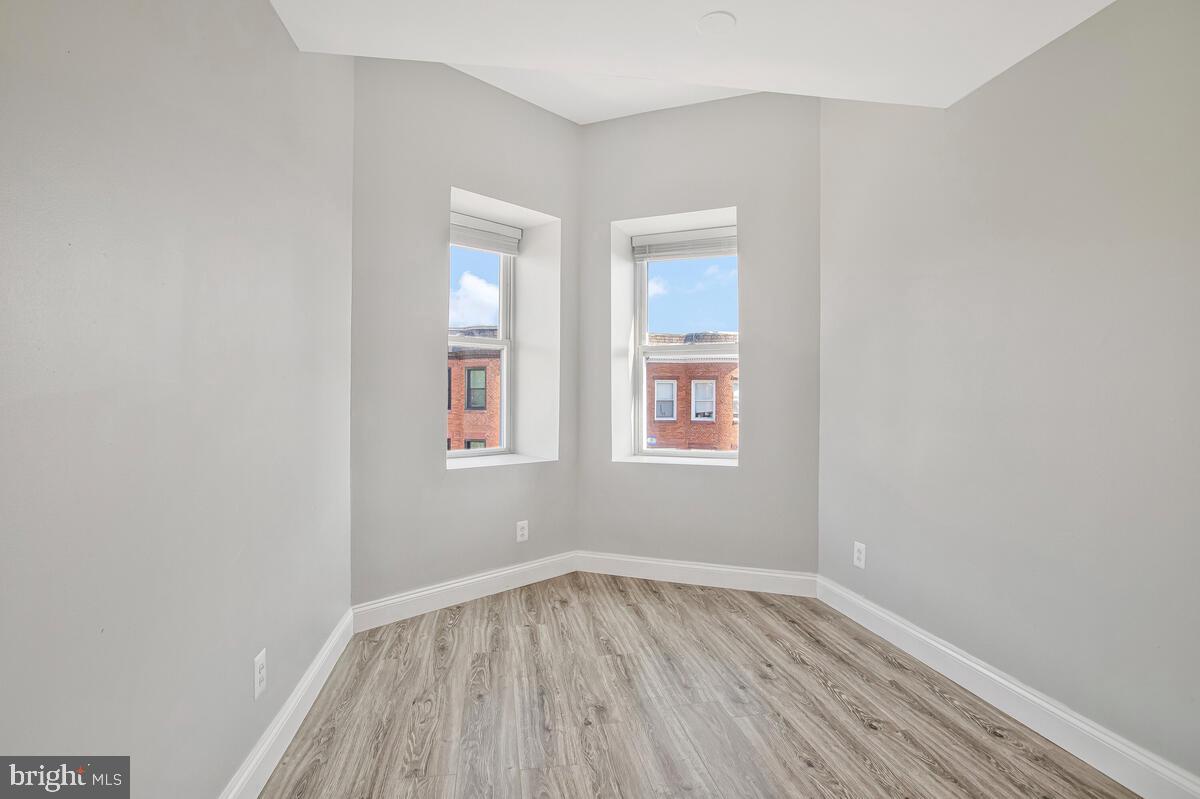 823 Newington Avenue Baltimore, MD 21217 - Photo 23 of 30 an empty room with wooden floor and windows