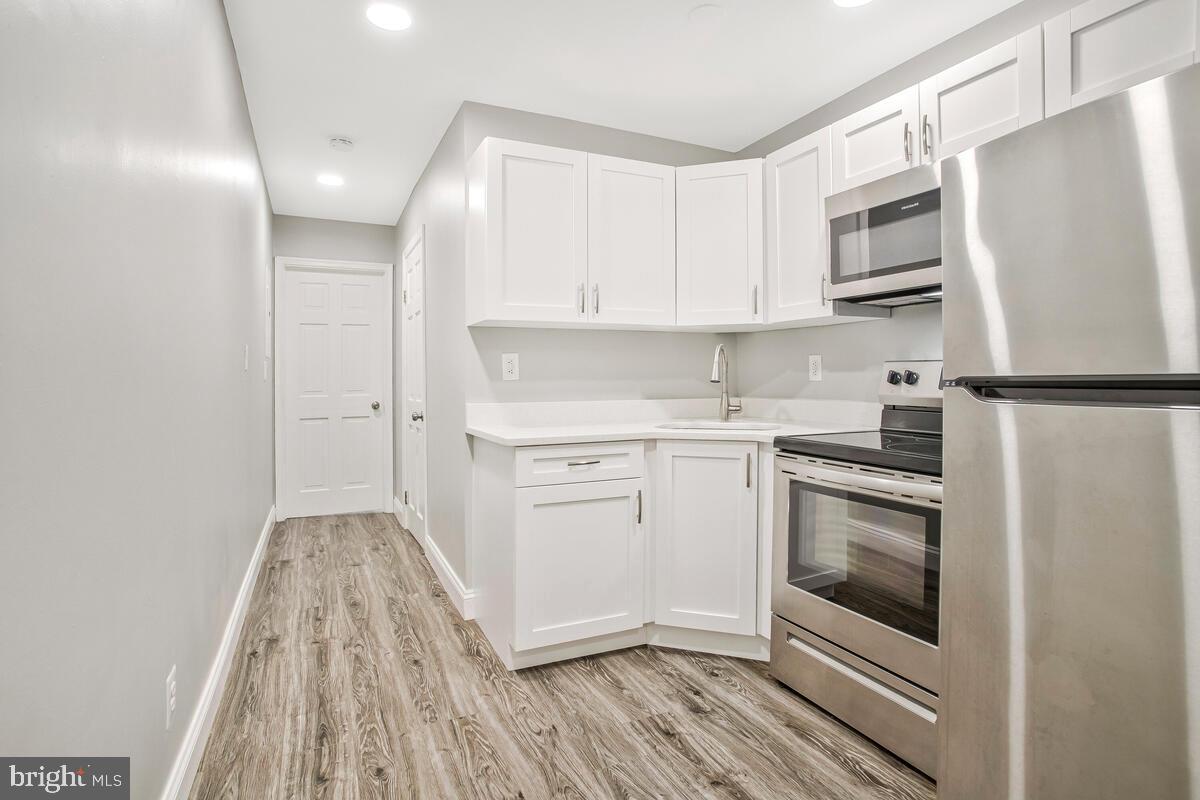 823 Newington Avenue Baltimore, MD 21217 - Photo 25 of 30 a kitchen with white cabinets stainless steel appliances and sink