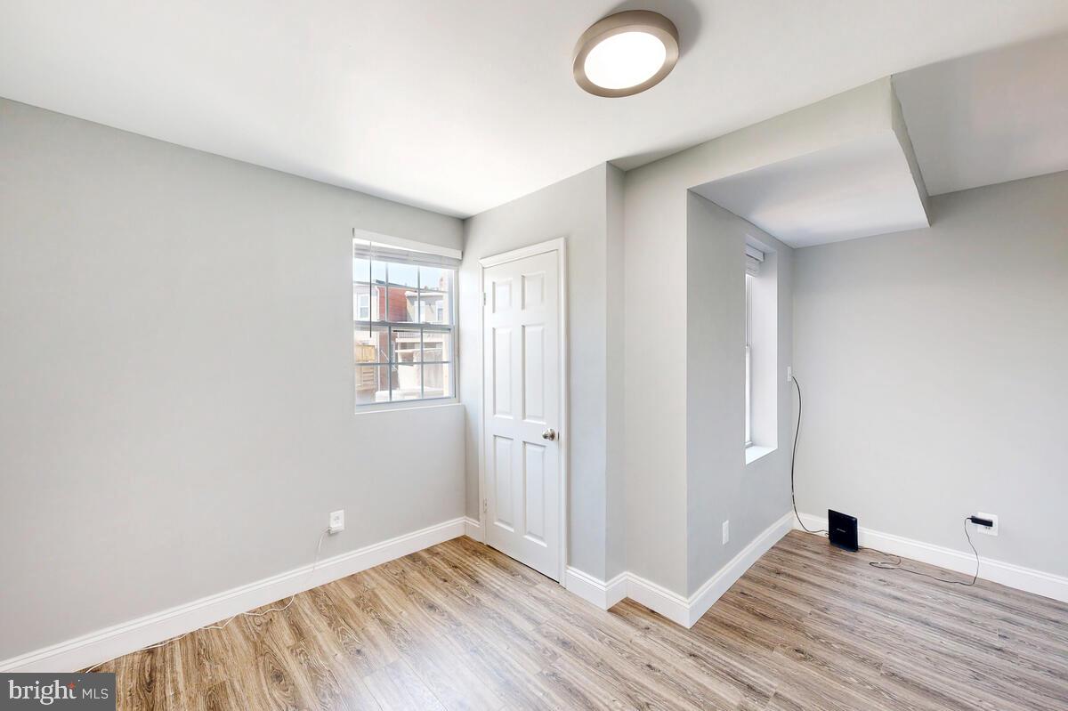 823 Newington Avenue Baltimore, MD 21217 - Photo 27 of 30 an empty room with wooden floor and windows