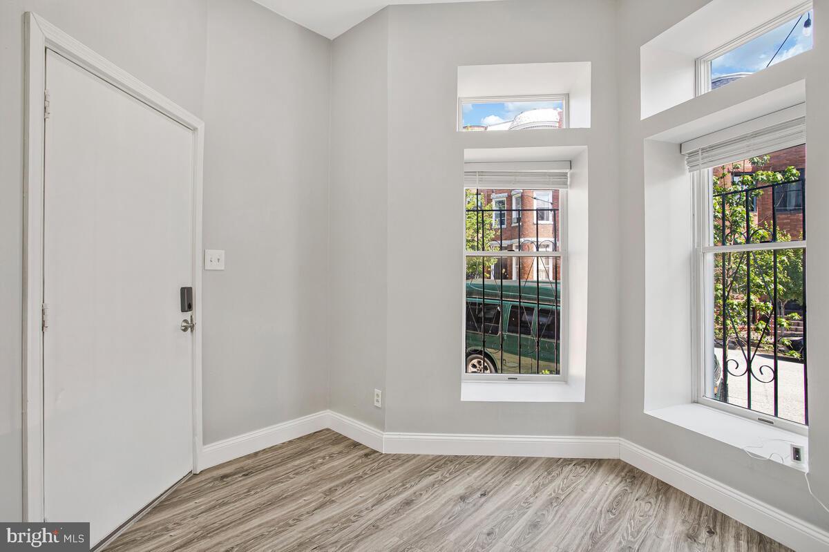 823 Newington Avenue Baltimore, MD 21217 - Photo 4 of 30 a view of an empty room with wooden floor and a window