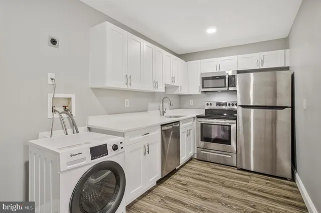 a kitchen with a sink a refrigerator and cabinets
