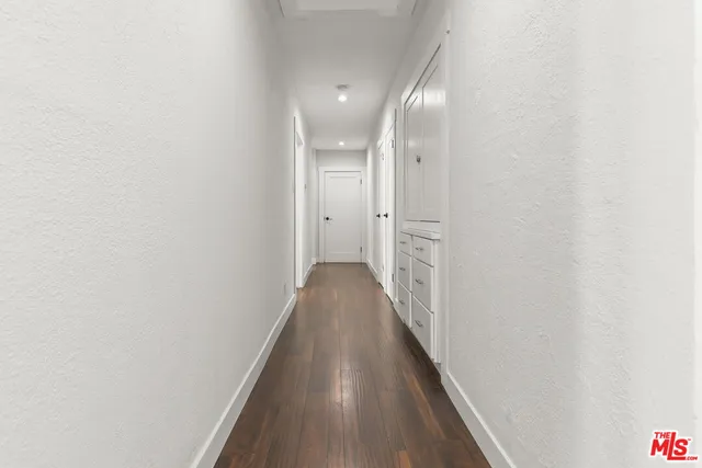 a view of a hallway with wooden floor