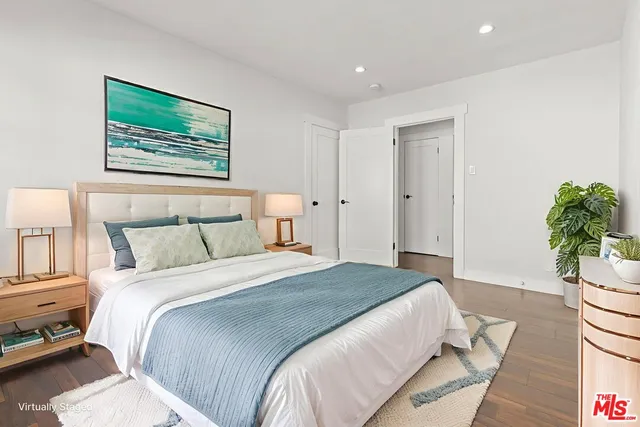 a bedroom with a large bed and a potted plant