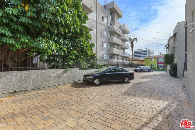 a view of a white building with a yard
