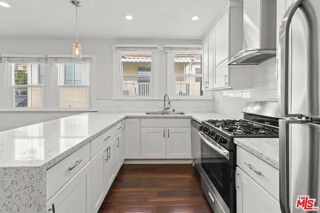 a kitchen with granite countertop a sink stove and cabinets