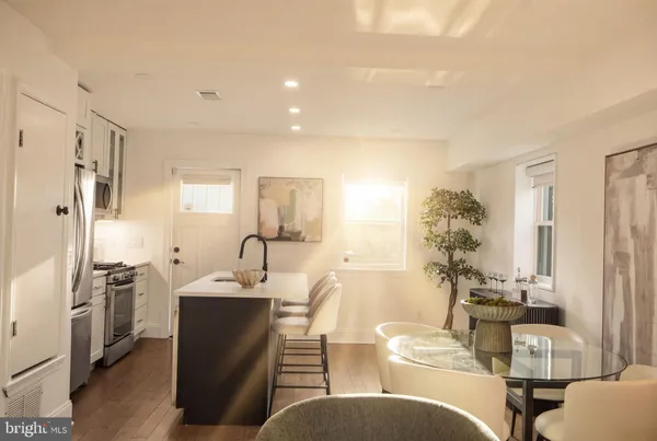 a living room with furniture a large window and a wooden floor