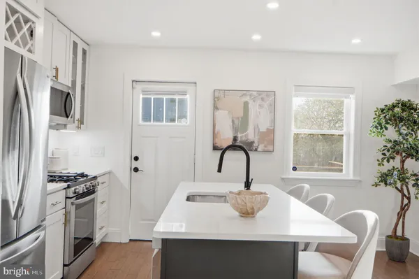 a kitchen with stainless steel appliances a table chairs and a refrigerator