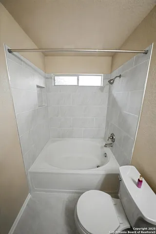 a bathroom with a toilet and a bath tub