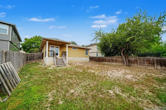 a backyard of a house with plants and tree