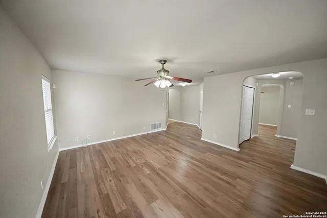 a view of empty room with wooden floor