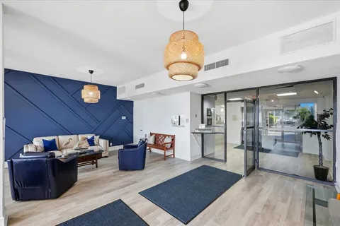 a living room with furniture a flat screen tv and kitchen view